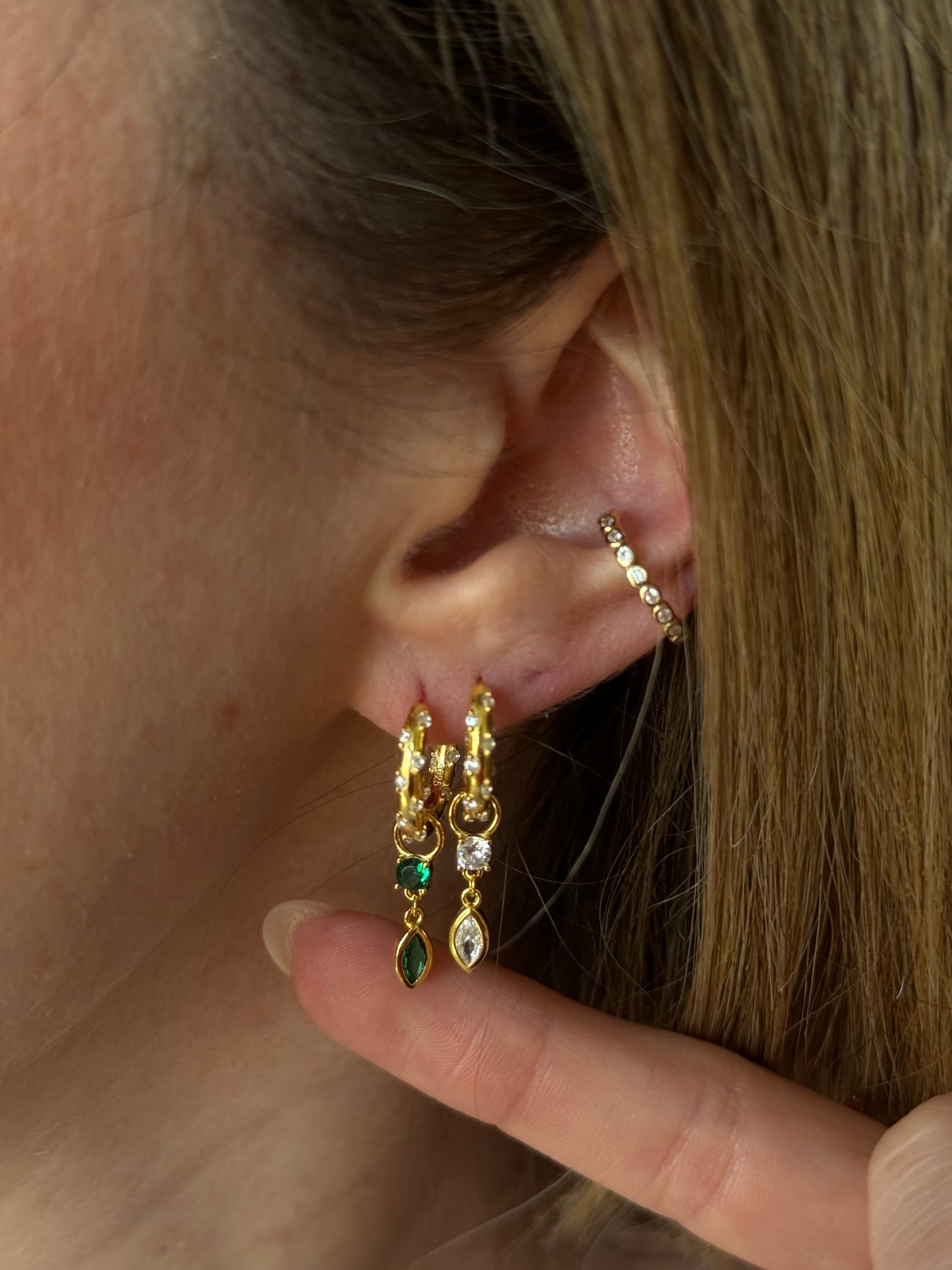 Add a splash of color to your daily routine with our green Yoli Drop Hoops! These playful hoops are sure to brighten up any outfit and put a smile on your face.
The combination of the gold color and the green stone creates a harmonious and eye-catching piece, suitable for both casual and more formal occasions.
Material: .925 Sterling Silver + 18K gold plated
Measurements: 1.10 x .57 in