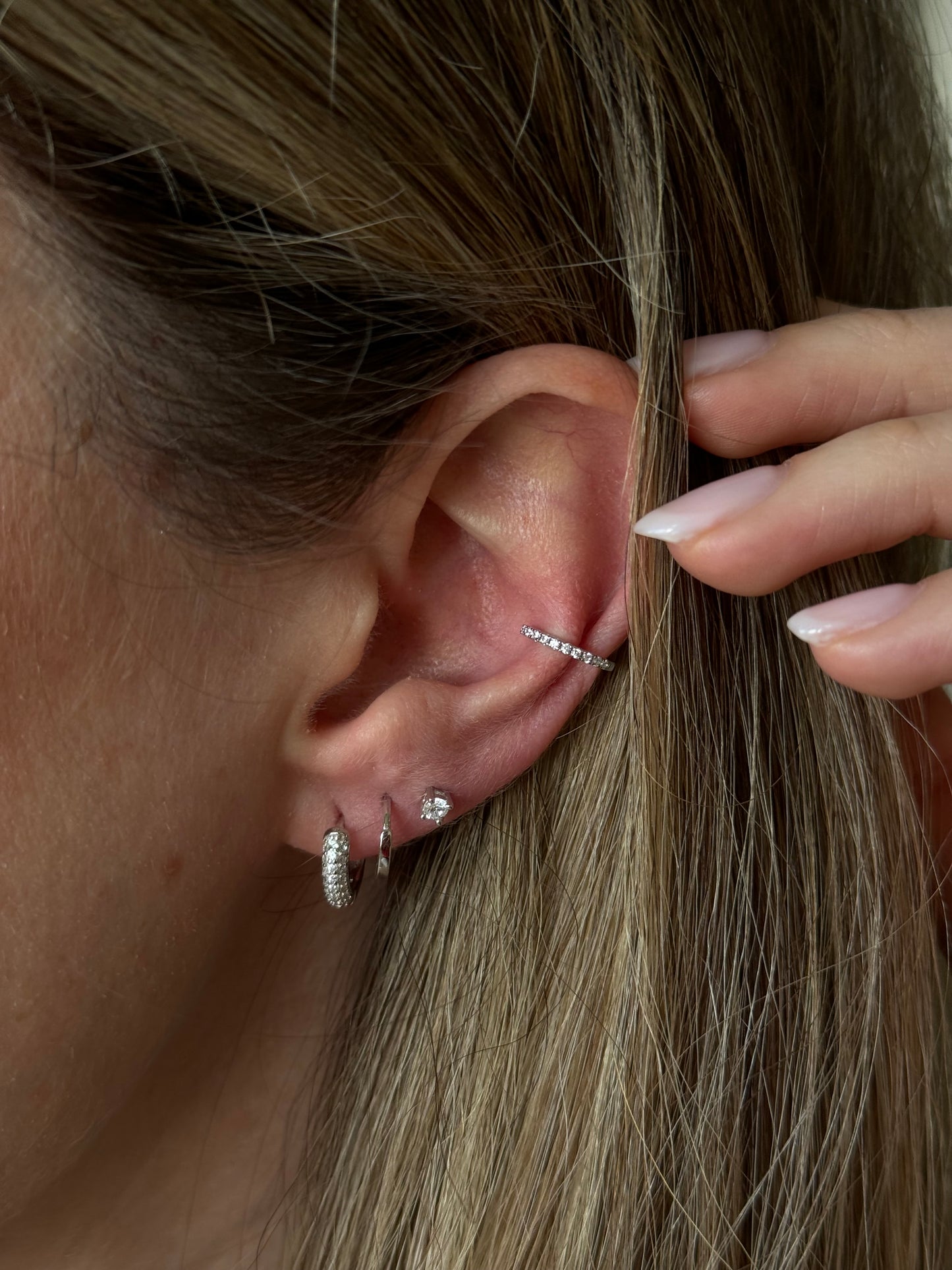 Illuminate your look with our Glimmer Silver trio Set, designed for the pierced woman who loves to sparkle. This trio set includes everything you need for a shining and sophisticated style upgrade. Perfect for any occasion, let our glimmering pieces bring out your unique beauty and confidence.
Material: 925 Sterling Silver
Measurements:
Sparkle stud: .09 in diameter
Plain hoop: .40 in diameter
sparkle hoop: .45 in diameter