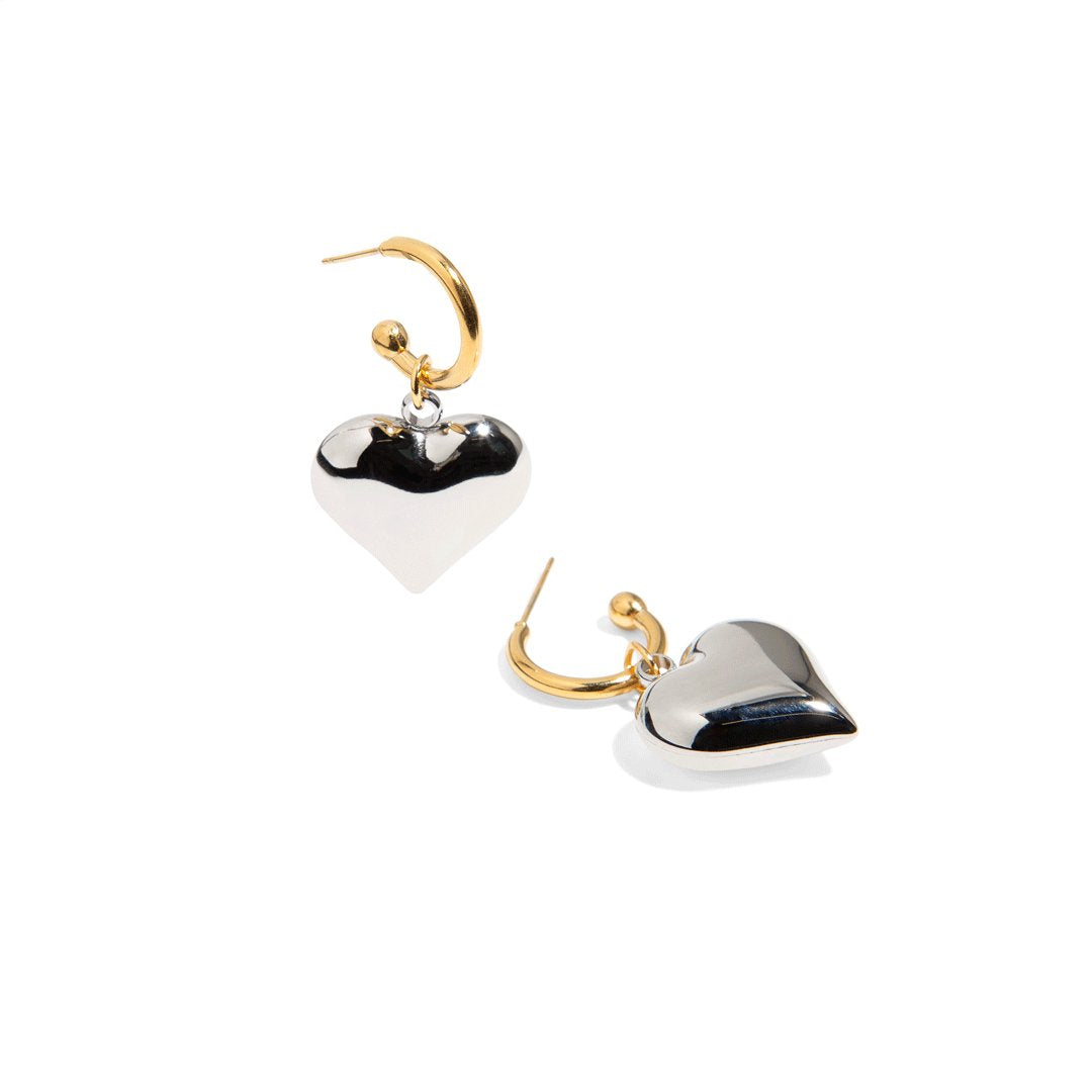 Make an elegant statement with our gold hoop earrings with silver heart charm! These earrings are perfect for adding a touch of love and sparkle to any outfit. Its unique and modern design will surely make you stand out on any occasion.
Material: Stainless steel with 18k gold plate
Measurement: 4cm total length. 2cm heart