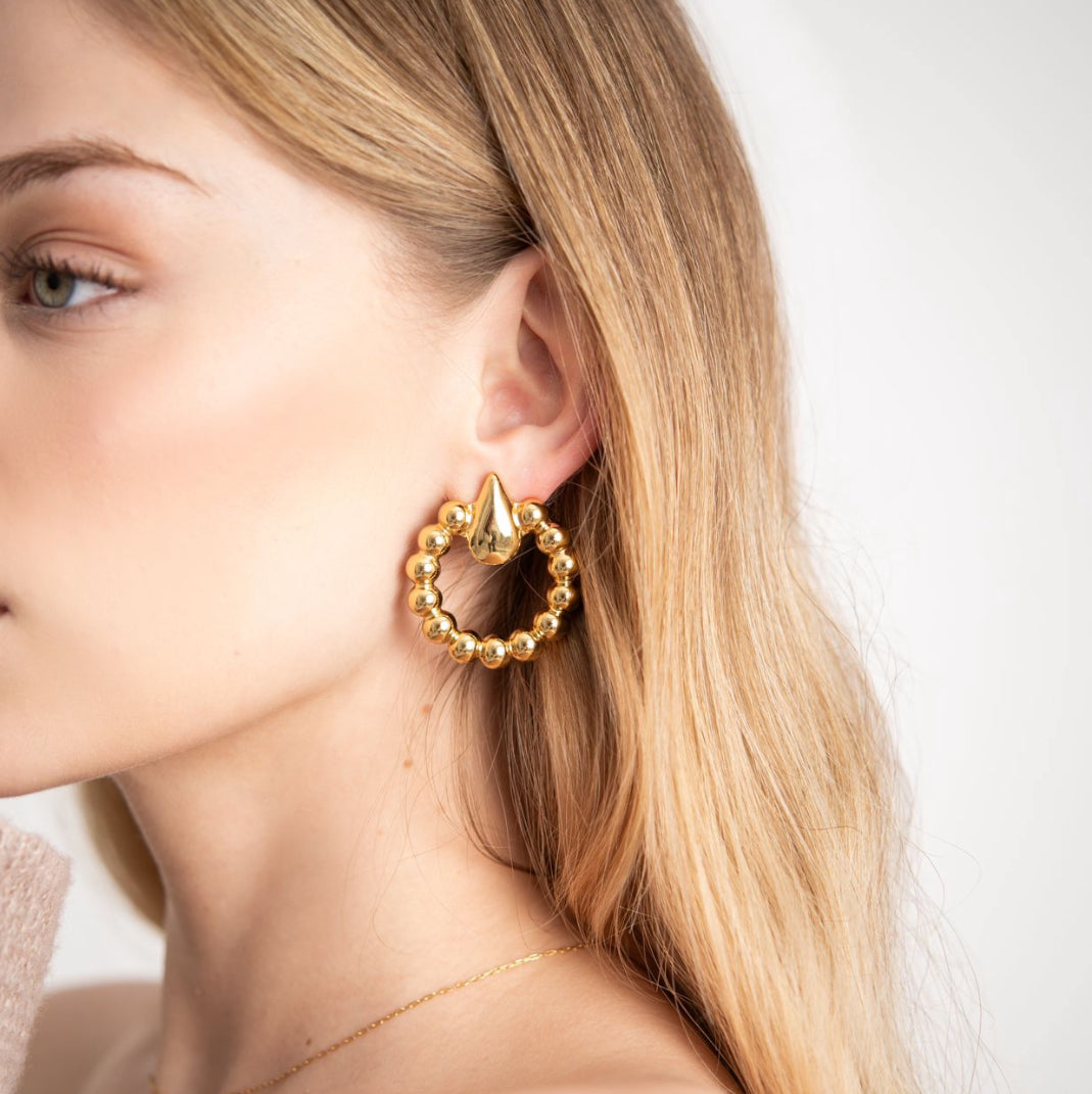 Long gold beaded earrings on model
Lightweight gold drop earrings for summer
Close-up of glam gold statement earrings