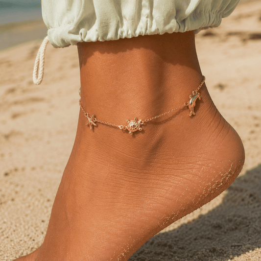 Gold anklet with starfish charm on a sandy beach