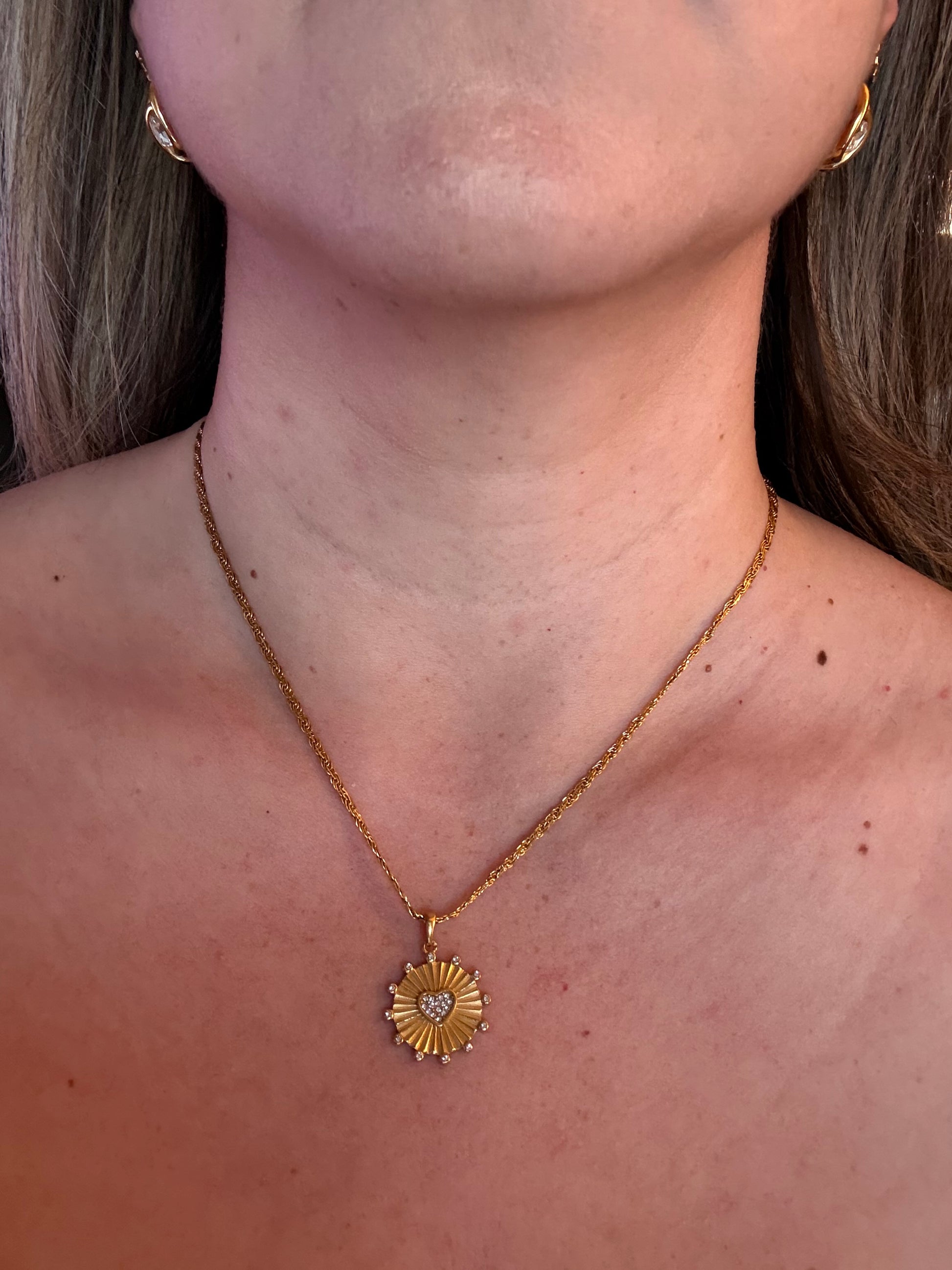 Sunburst heart medallion necklace styled for layering