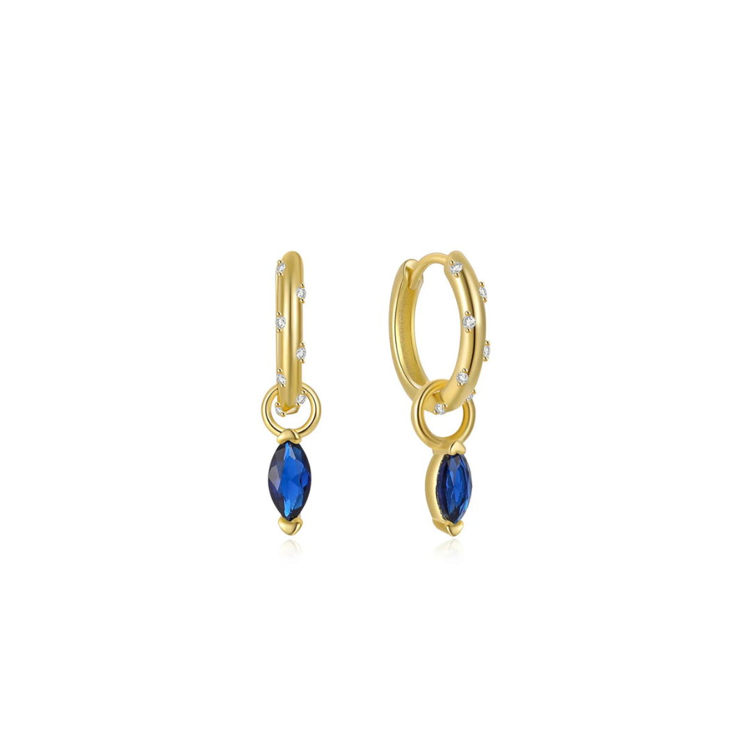 Add a touch of sparkle to your look with these charming blue hoops. The oval shape adds a unique twist, while the blue charm enhances any outfit. Perfect for the fashion-forward and the playful at heart.


Material: .925 Sterling Silver + 14K gold plated


Measurements: .50 in x .50 in 

pendant: .25 in x .25 in