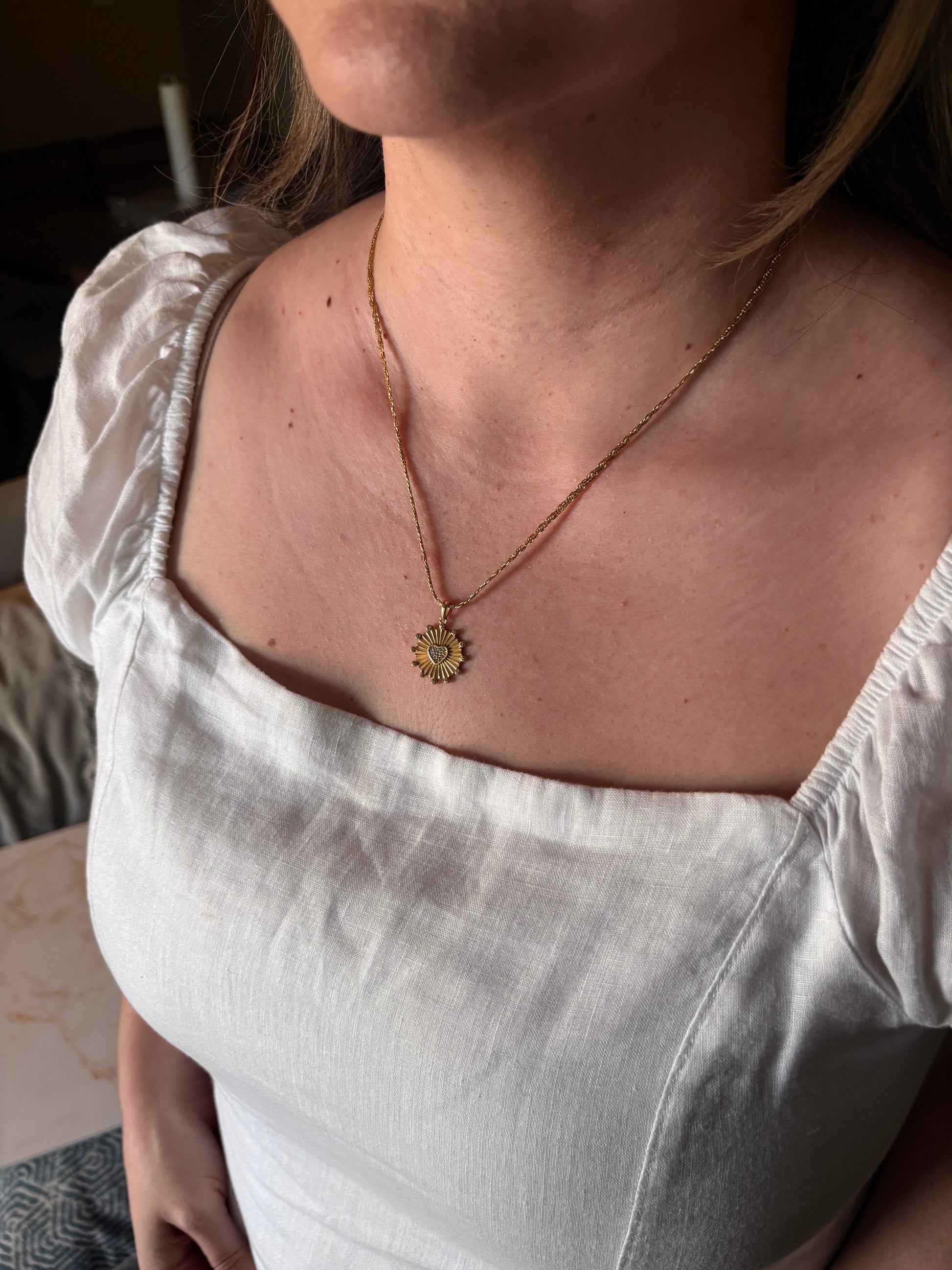 Sunburst heart pendant necklace close-up, pave crystal detail