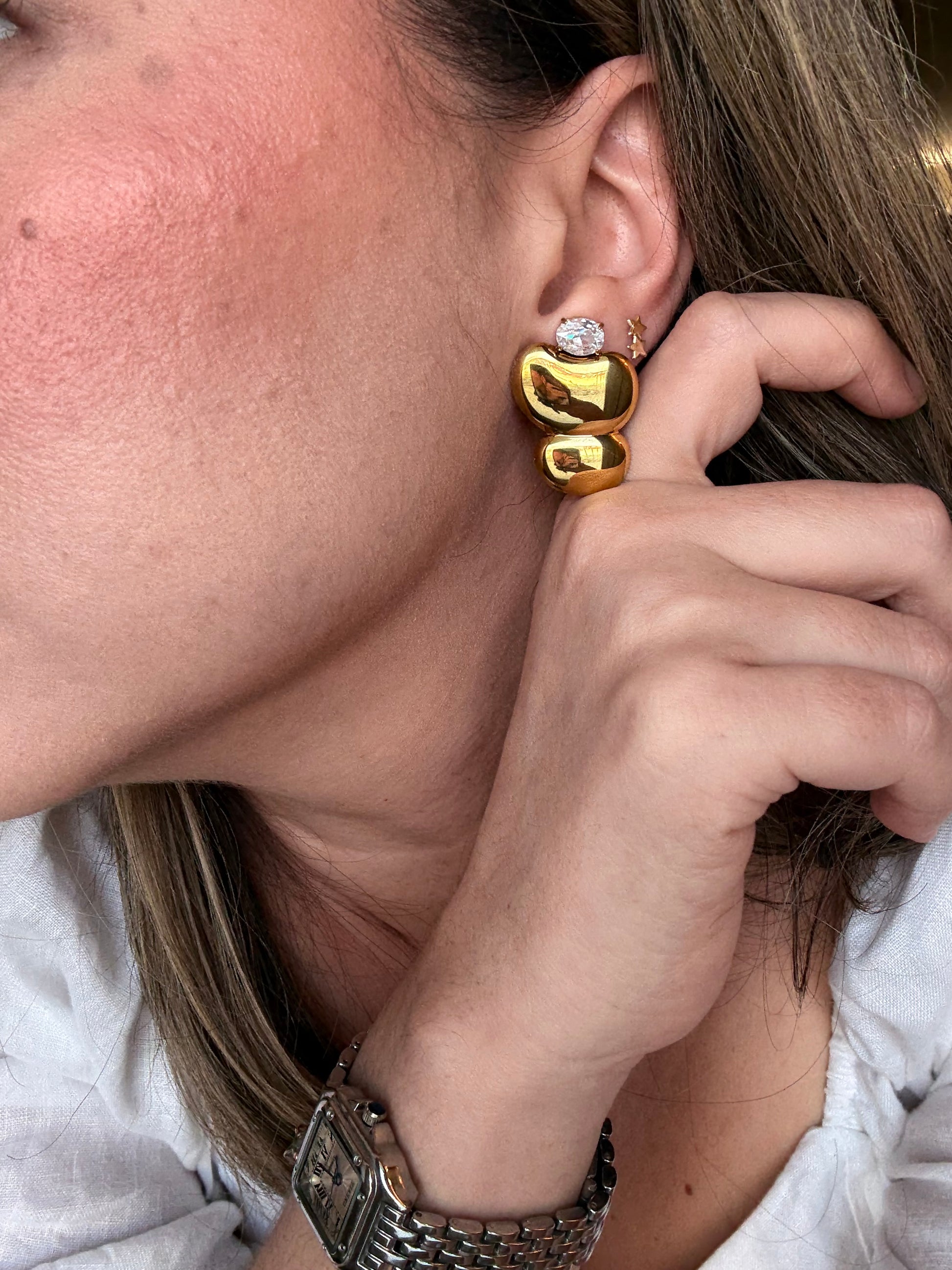 Chunky double heart drop earrings worn on ear