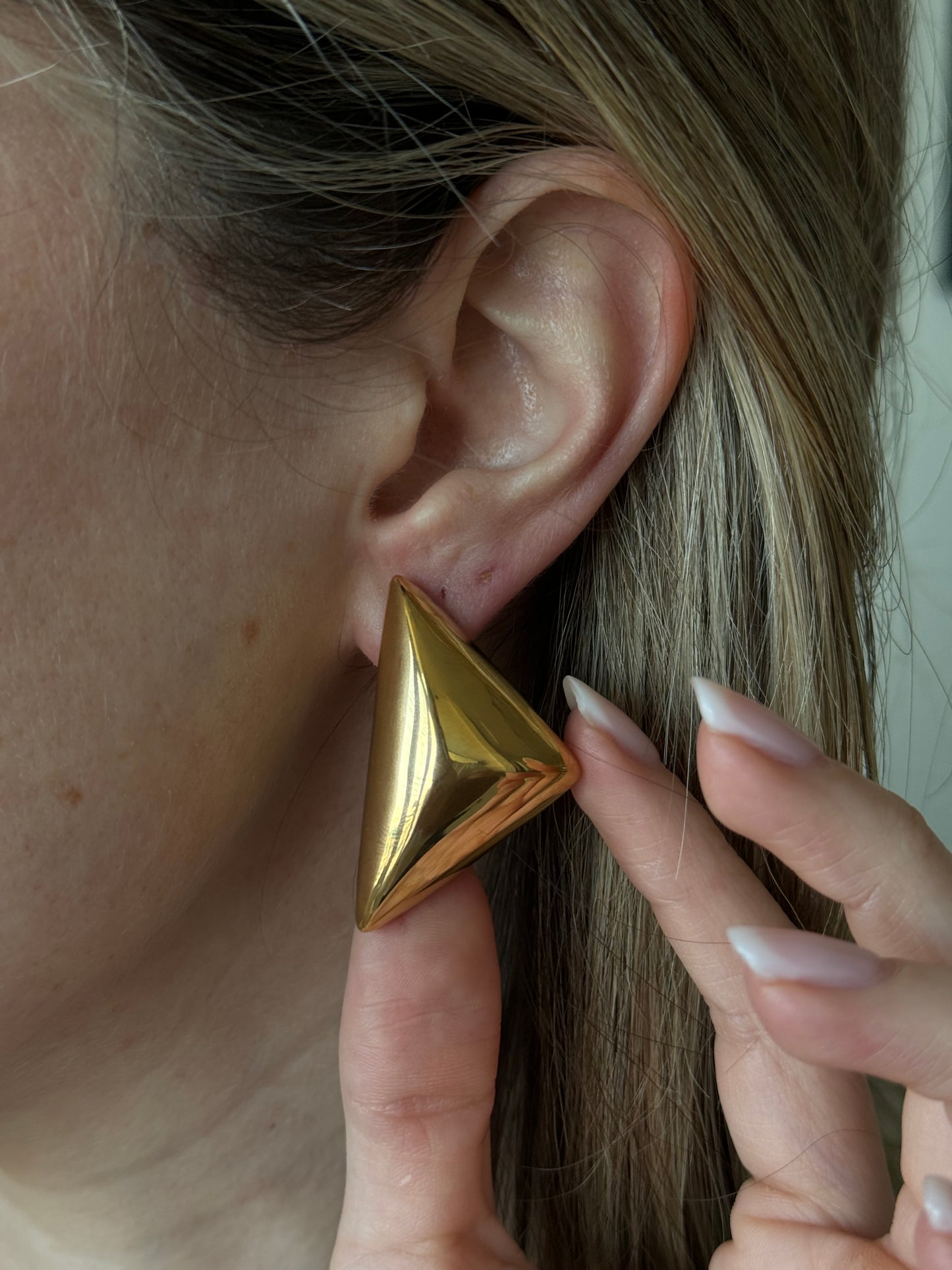 Add a touch of elegance to your wardrobe with our GOLDEN TRIANGLE BELEN EARRINGS. These stylish earrings feature a beautiful golden triangle design, adding a chic and sophisticated touch to any outfit. Made with high-quality materials, these earrings are perfect for any occasion and make a timeless addition to your jewelry collection.

Material: Stainless Steel + 18K gold plated

Measurements: 1.6 x .95 in