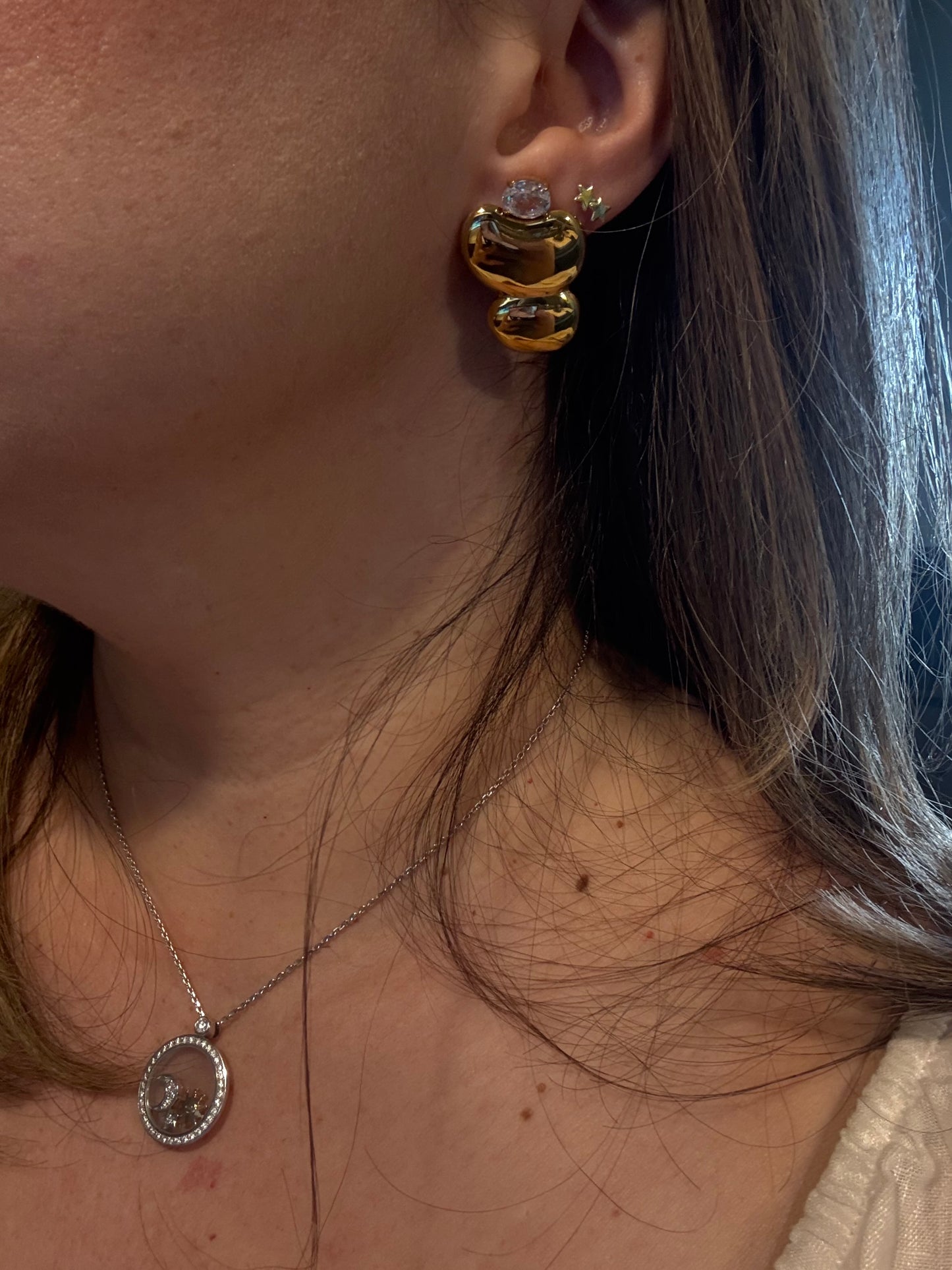 Chunky gold drop earrings detail showing double heart sculpture