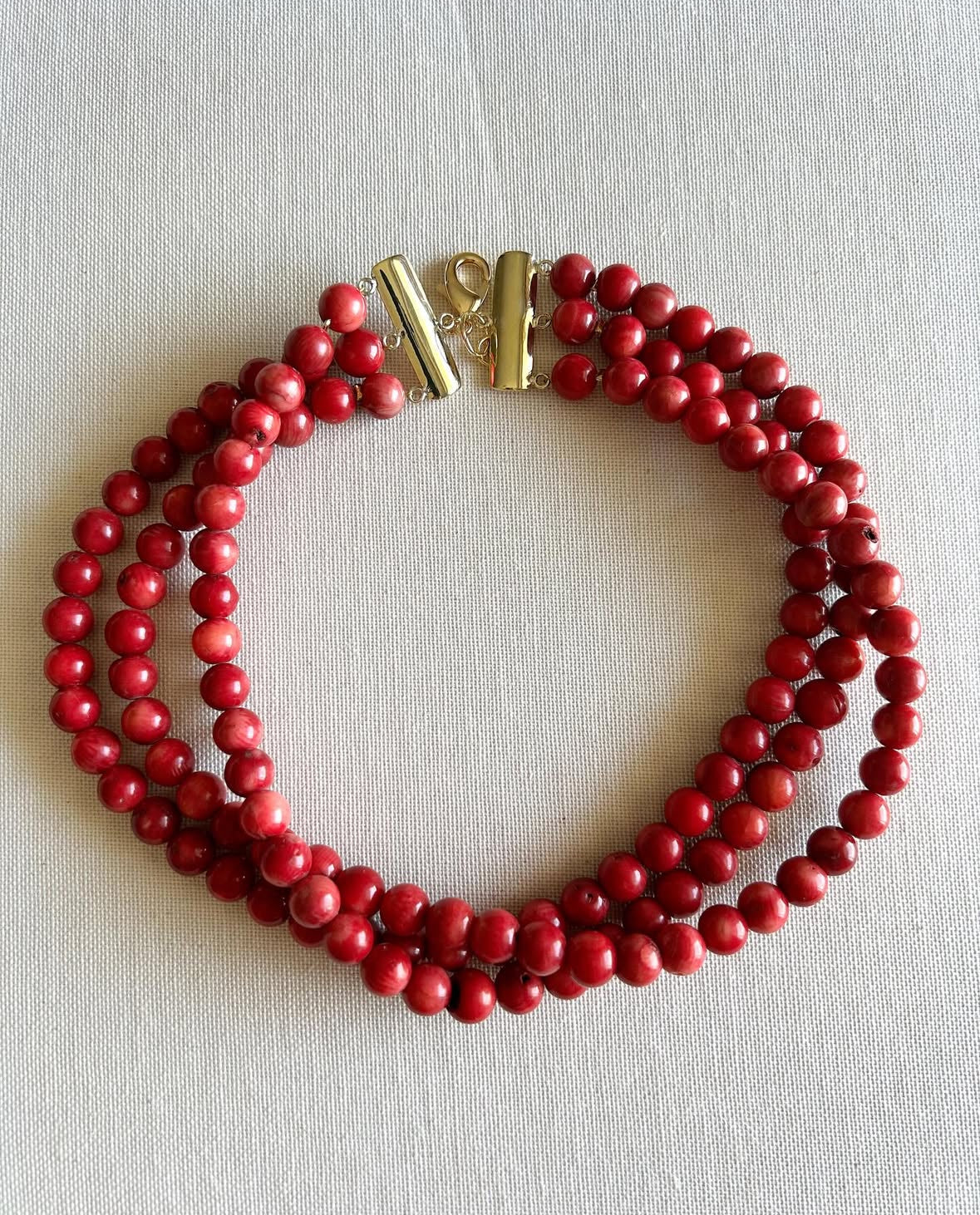 Gold Coral Charm Necklace on white background with natural coral beard. 