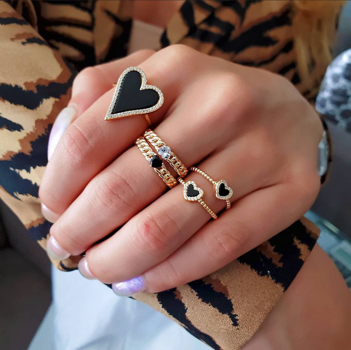 Gold heart ring with black onyx stone worn on hand. lifestyle shot 