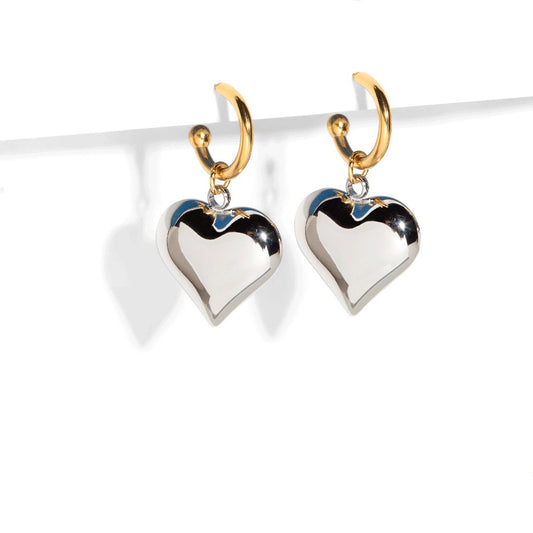 Make an elegant statement with our gold hoop earrings with silver heart charm! These earrings are perfect for adding a touch of love and sparkle to any outfit. Its unique and modern design will surely make you stand out on any occasion.

Material: Stainless steel with 18k gold plate
Measurement: 4cm total length. 2cm heart