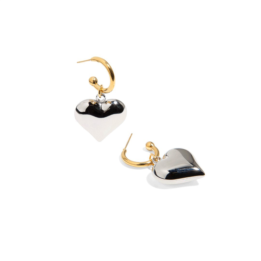 Make an elegant statement with our gold hoop earrings with silver heart charm! These earrings are perfect for adding a touch of love and sparkle to any outfit. Its unique and modern design will surely make you stand out on any occasion.

Material: Stainless steel with 18k gold plate
Measurement: 4cm total length. 2cm heart