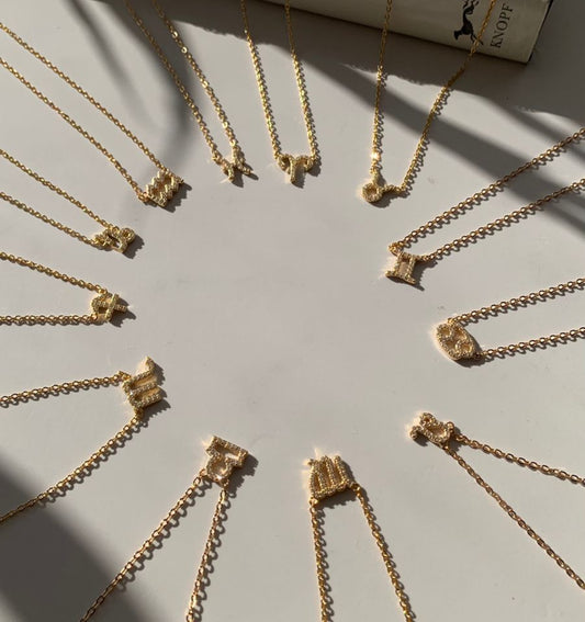 Leo zodiac necklace layered with gold chain necklaces